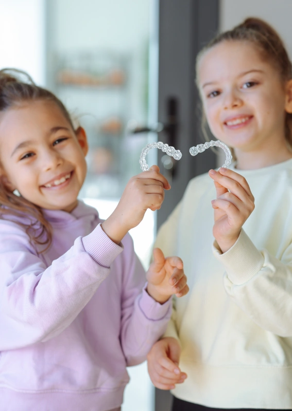 Hand holding a clear aligner over its storage case, Precision Dental Care, Imperial, MO